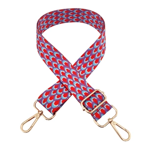 Close-up of colorful peacock patterned woven bag strap with golden lobster clasps