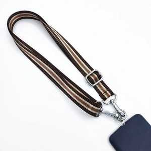 Detail of adjustable crossbody phone strap with green and red striped nylon webbing