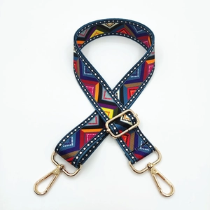 Close-up of adjustable ethnic geometric pattern canvas strap with gold metal hooks