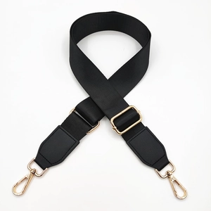 Detail of adjustable black nylon strap with gold metal hooks and leather reinforced ends