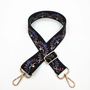 Detail of adjustable wide bag strap with colorful ethnic embroidery and gold hardware