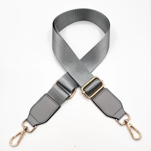Close-up of adjustable grey nylon shoulder strap with pale gold metal buckle and lobster clips
