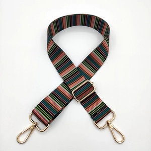 Detail of adjustable colorful striped bag strap with premium gold metal swivel hooks