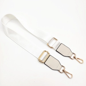 Detail of adjustable white nylon strap with golden swivel clasps and beige leather ends