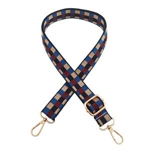 Close-up of adjustable woven strap with colorful checkerboard pattern and gold metal hooks