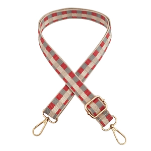 Detail of red and grey checkered woven strap with adjustable gold metal buckle hardware