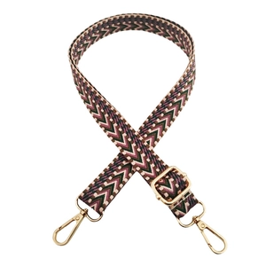 Close-up of geometric woven shoulder strap with gold metal lobster clasps and buckle