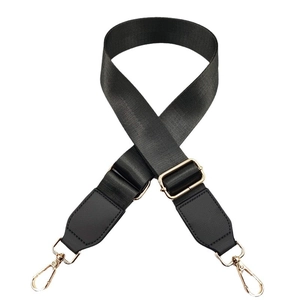 Adjustable black nylon shoulder strap with gold metal hardware and faux leather ends