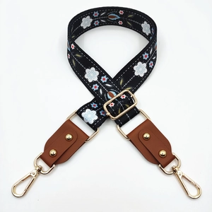 Detail of adjustable vintage floral bag strap with gold rivets and leather trim