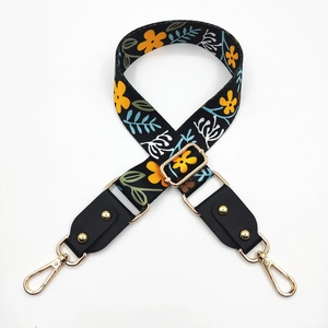 Close-up of ethnic floral strap with yellow flowers and golden metal hooks