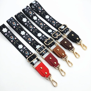 Close-up of colorful ethnic embroidery bag straps with gold metal hooks in five colors
