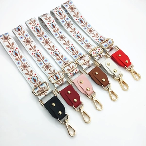 Detailed showcase of ethnic floral woven bag straps with gold hardware and leather ends