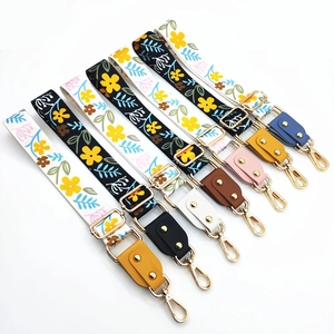 Detail of colorful floral wide shoulder straps with gold hardware and leather ends