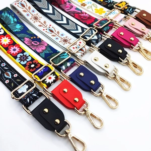Detail view of colorful patterned shoulder straps with gold hooks and leather ends