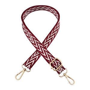 Detail of adjustable woven strap with dark red herringbone pattern and gold metal hooks