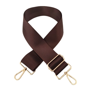 Detail of dark brown adjustable nylon shoulder strap with gold metal buckles and hooks