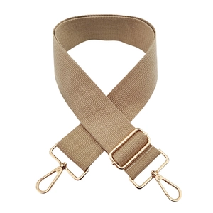 Detail of beige canvas bag strap with adjustable gold-tone buckle and lobster clasps