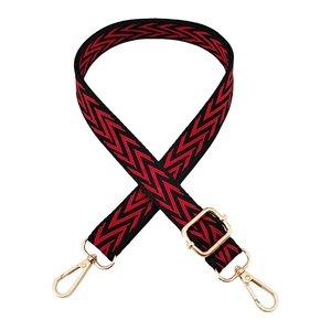 Adjustable woven shoulder strap with red and black chevron pattern and gold metal hooks
