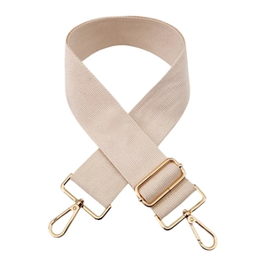 Macro detail of adjustable beige canvas bag strap with high-quality gold metal hardware