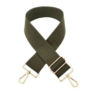 Detail of army green adjustable canvas bag strap with high-gloss gold metal hardware