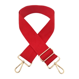 Detail of red thick nylon bag strap with adjustable golden buckle and lobster clasps