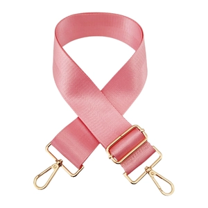 Macro view of pink nylon bag strap with herringbone texture and gold metal hooks