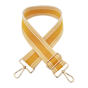 Detail of adjustable mustard yellow 5cm wide bag strap with gold metal swivel hooks
