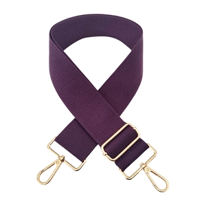 Close-up of adjustable purple cotton wide shoulder strap with gold metal hooks for handbags