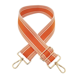 Detail of adjustable orange canvas shoulder strap with gold metal hooks and white side stripes