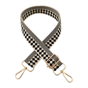 Detail of checkered jacquard strap with gold hardware hooks and adjustment buckle