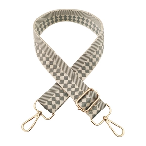 Detail of gray and beige checkered woven shoulder strap with gold metal lobster clasps