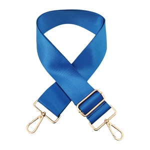 Close-up of electric blue nylon bag strap with gold lobster clasps and twill texture