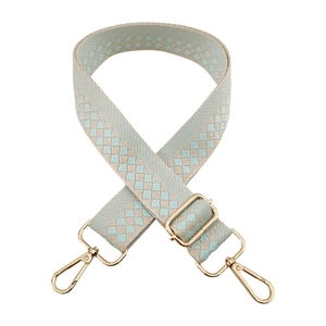 Detail of blue and beige checkered woven shoulder strap with gold metal lobster clasps