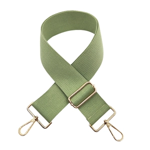 Close-up of Morandi green woven bag strap with golden metal hardware and twill pattern