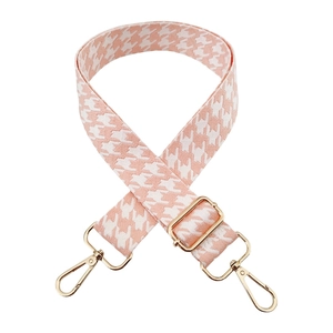Detailed view of pink houndstooth wide strap with shiny gold swivel hooks and buckle