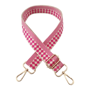 Close-up of pink and white checkered wide replacement shoulder strap with gold metal buckles
