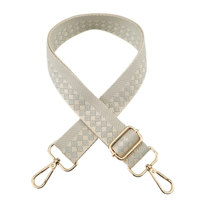 Detail of adjustable geometric checkered strap with high-quality gold metal hardware