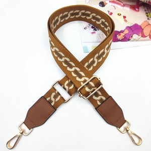 Detail of adjustable geometric strap with leather ends and golden swivel lobster hooks
