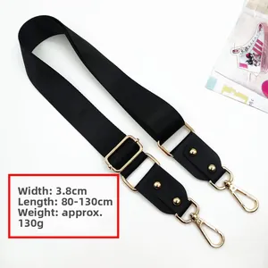 Detail of 3.8cm wide adjustable black nylon bag strap with golden metal hardware and rivets
