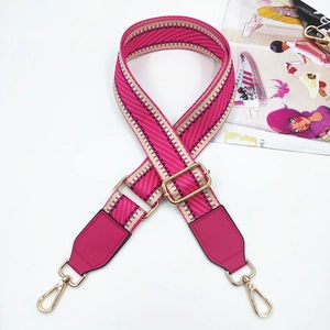 Detail of adjustable woven strap with pink leather ends and gold metal snap hooks
