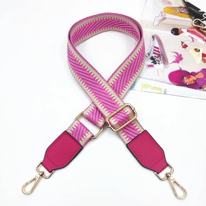 Detail of colorful woven shoulder strap with pink leather ends and gold metal buckle