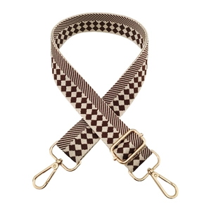 Detail of adjustable brown and beige diamond checkered wide shoulder bag strap with gold hooks