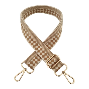 Close-up of adjustable wide woven bag strap with beige and dark brown geometric pattern