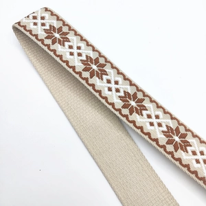 Close-up of thick ethnic jacquard strap with snowflake embroidery on white background