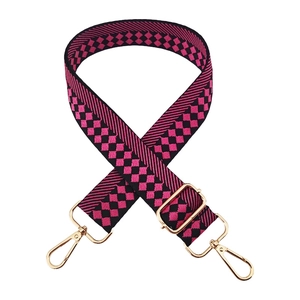 Detail of adjustable woven handbag strap with magenta and black checkered jacquard and gold clips