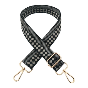 Detail of checkered woven wide shoulder strap with gold swivel lobster clasps for bags