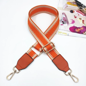 Adjustable woven shoulder strap in orange and beige with golden metal swivel hooks