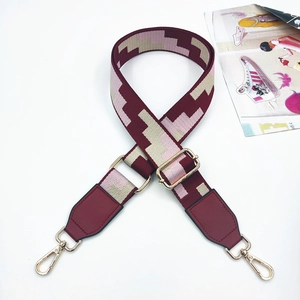 Close-up of adjustable wide geometric shoulder strap with gold-tone swivel metal hooks