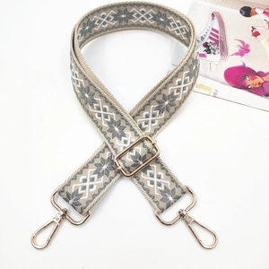 Detailed view of geometric ethnic style embroidery shoulder strap with gold metal buckle