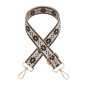 Detail of adjustable woven bag strap with black and white geometric snowflake patterns